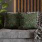 Green patterned pillows on a gray sofa with a wooden slat wall in the background