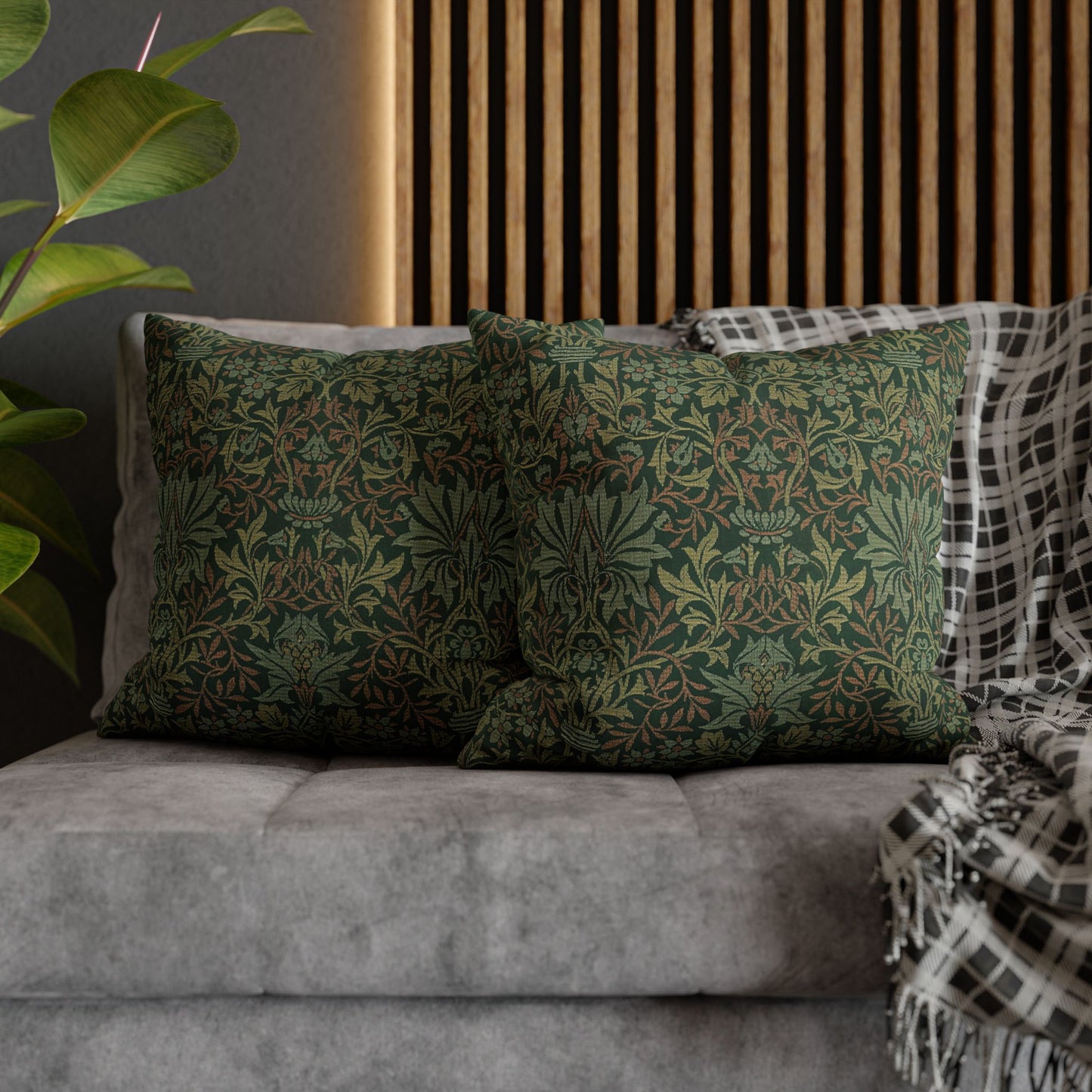 Green patterned pillows on a gray sofa with a wooden slat wall in the background