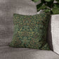 Green patterned pillow on a gray sofa with a blurred plant in the background