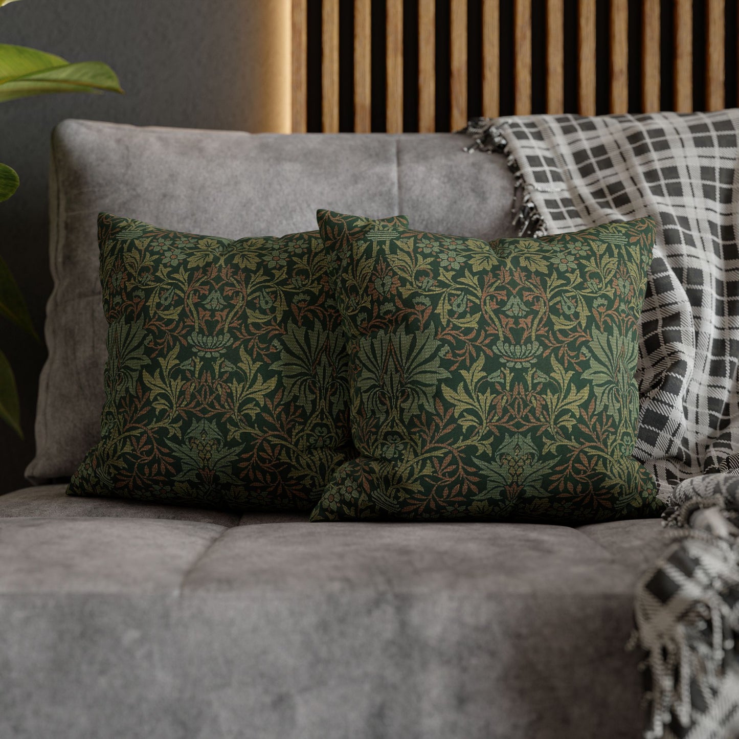 Green patterned pillows on a gray sofa with a wooden headboard in the background