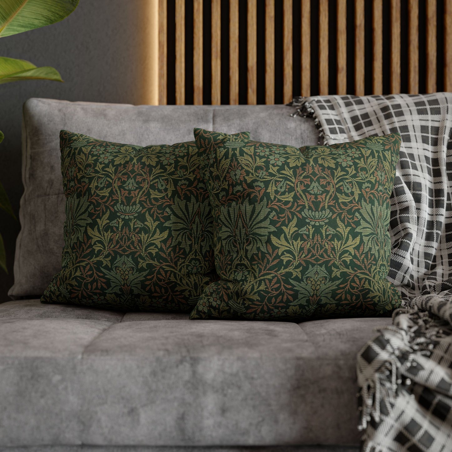 Green patterned pillows on a gray sofa with a wooden headboard in the background