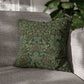 Decorative pillow with a pattern of bears, roses, and candles on a polka dot background, placed on a gray couch.