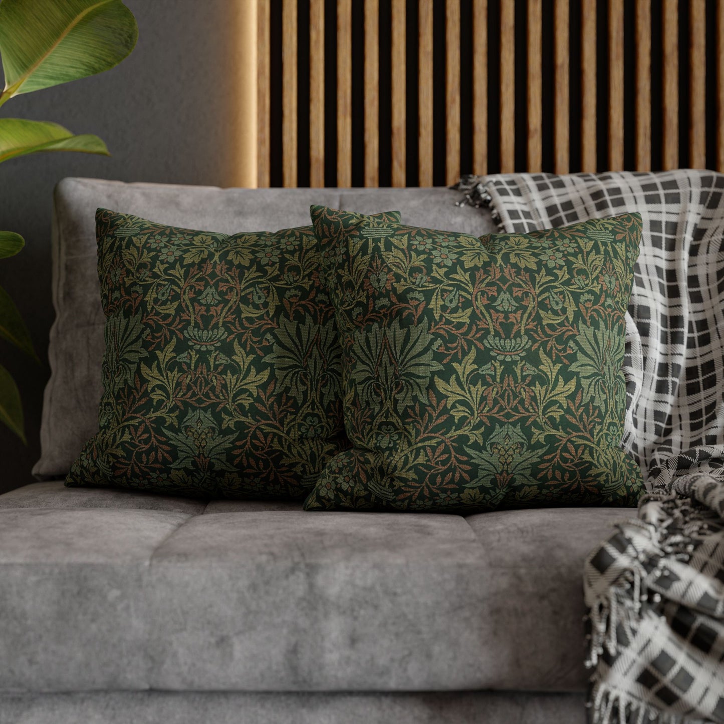 Green patterned pillows on a gray sofa with a wooden headboard in the background