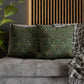 Green patterned pillows on a gray sofa with a wooden slat wall in the background