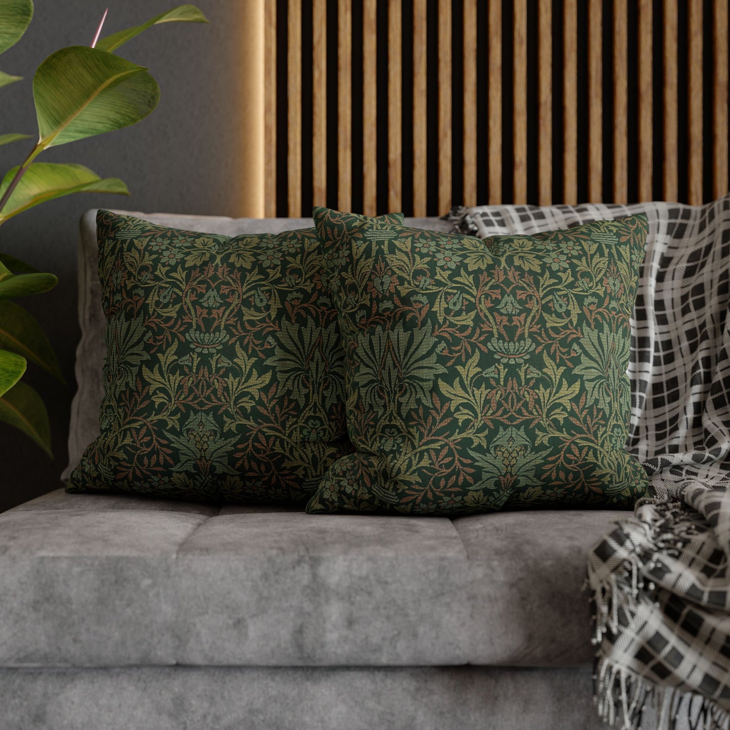 Green patterned pillows on a gray sofa with a wooden slat wall in the background