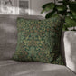 Green patterned pillow on a gray sofa with a blurred indoor background