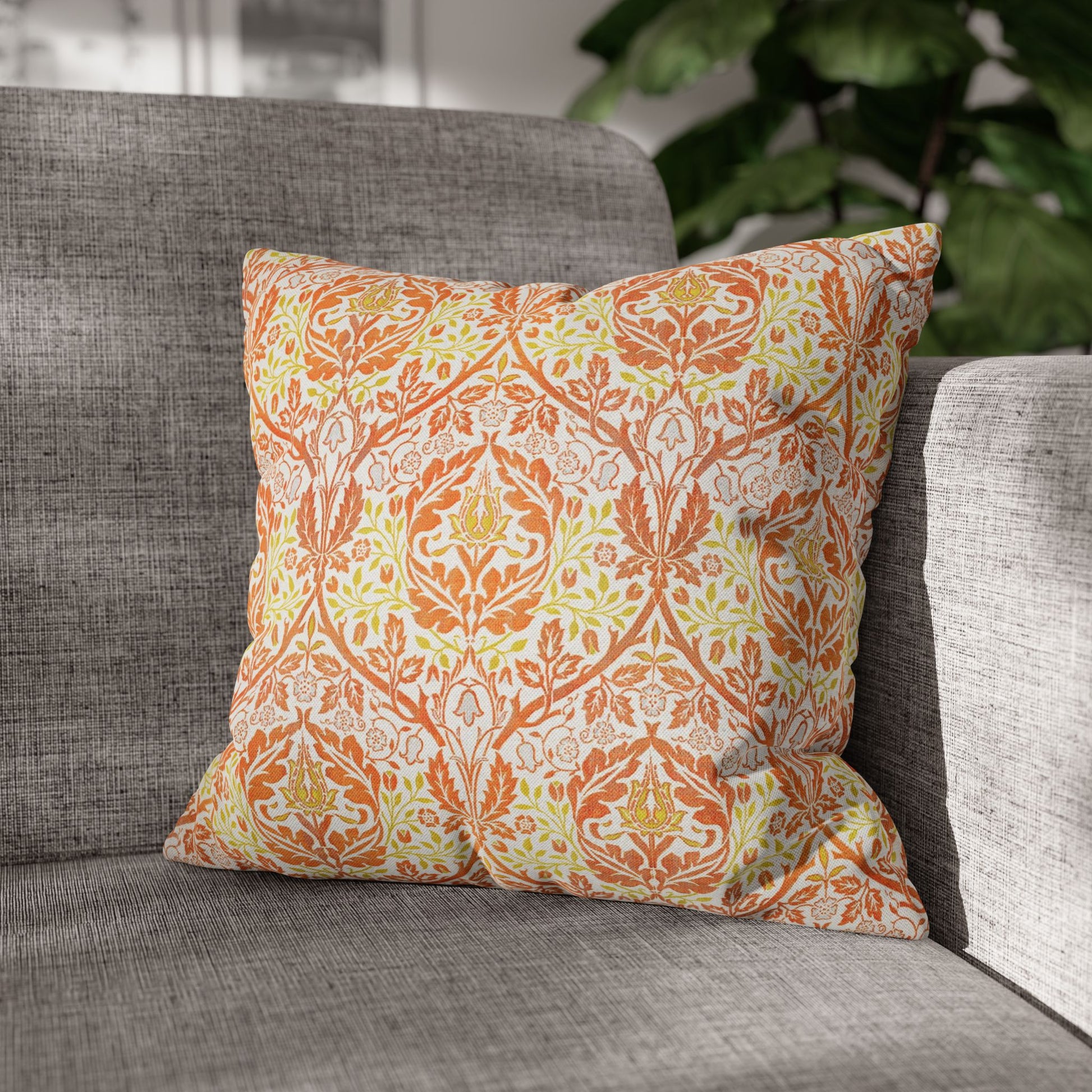 Decorative pillow with orange and green pattern on a gray sofa - William Morris Golden Bough
