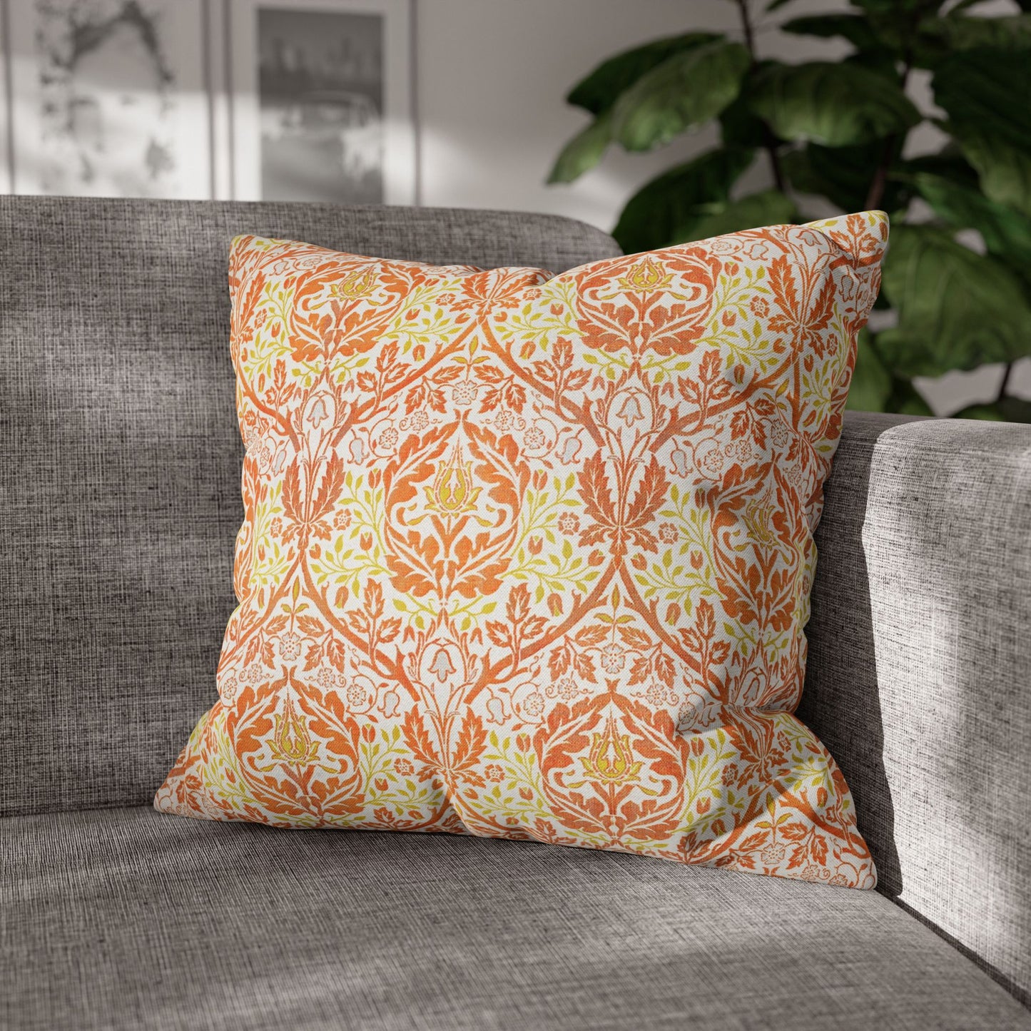 Decorative pillow with orange and green pattern on a gray sofa