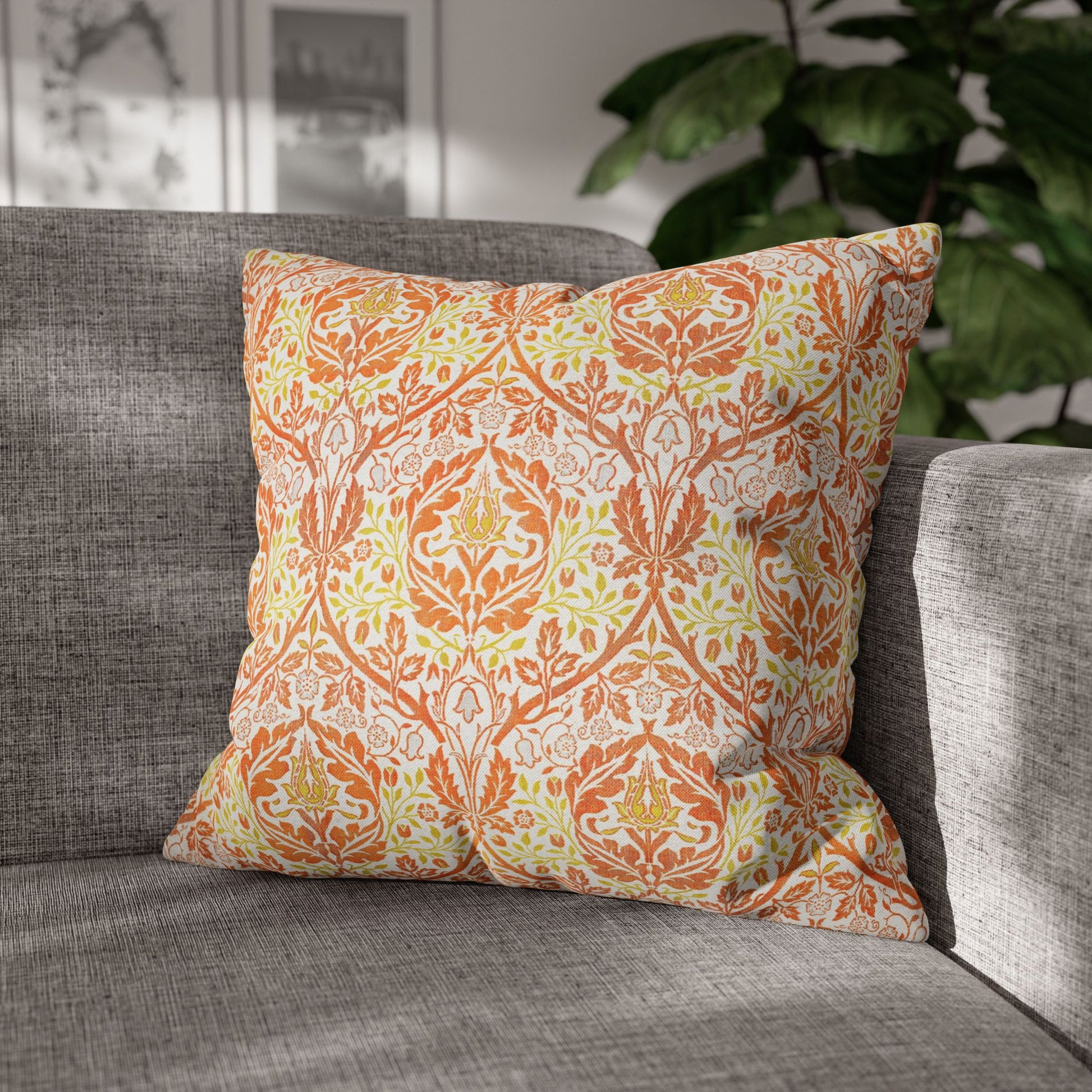 Decorative pillow with orange and green pattern on a gray sofa