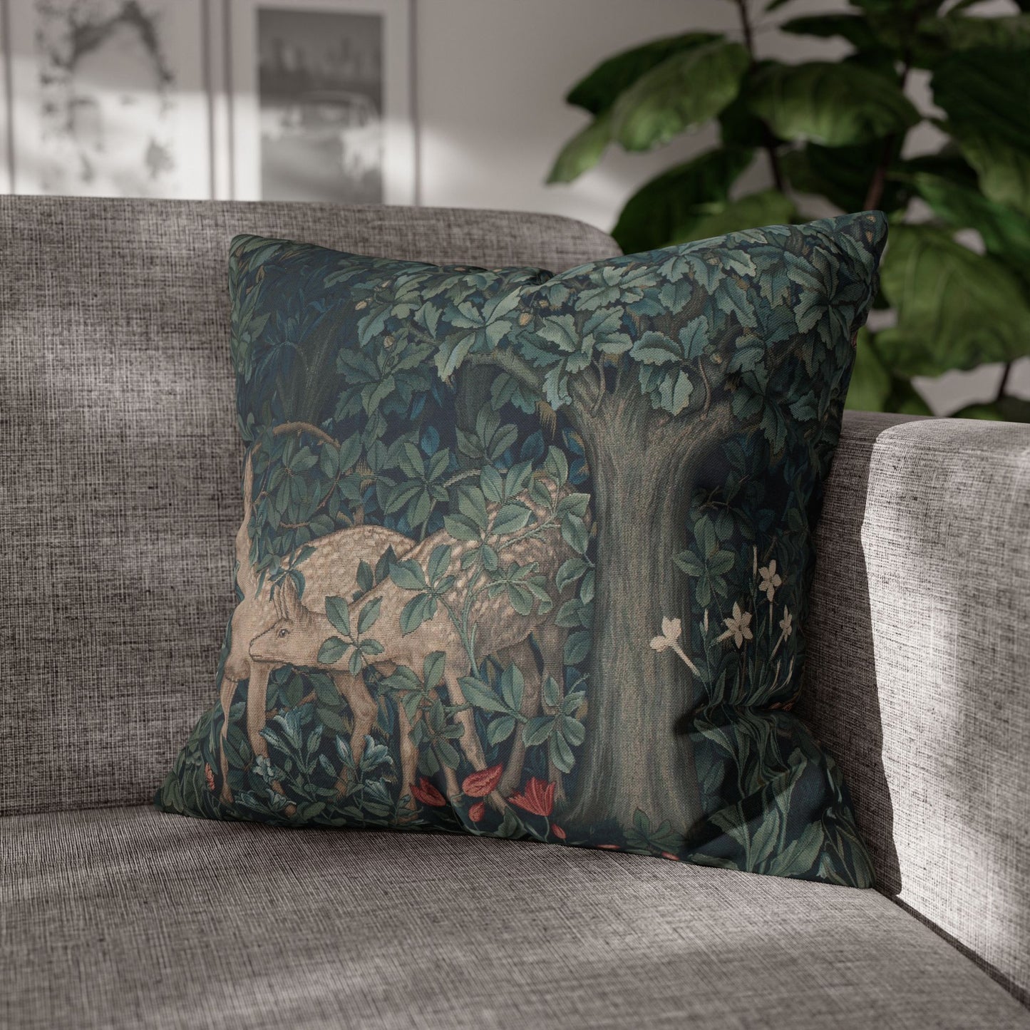 Decorative pillow with a nature-themed design featuring a deer and tree on a gray sofa.