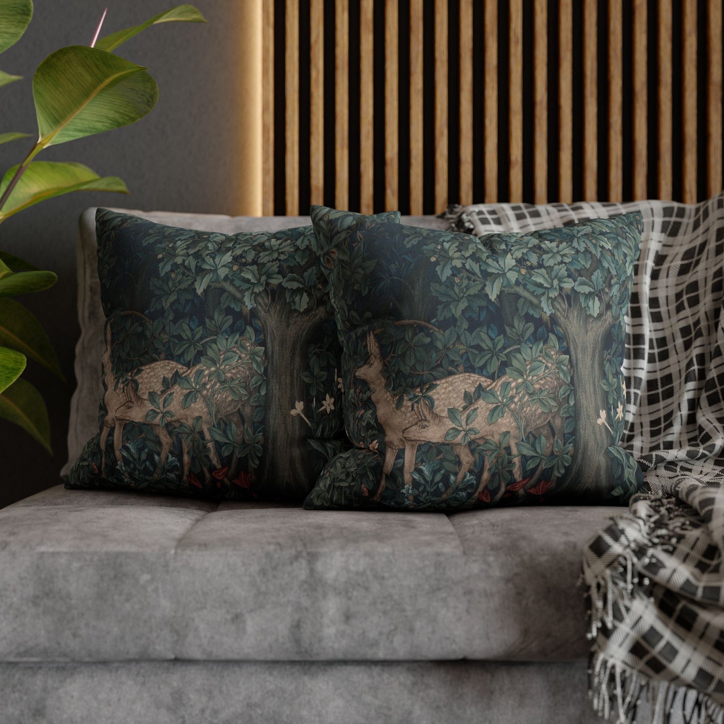 Decorative pillows with deer design on a gray sofa against a wooden slat wall.