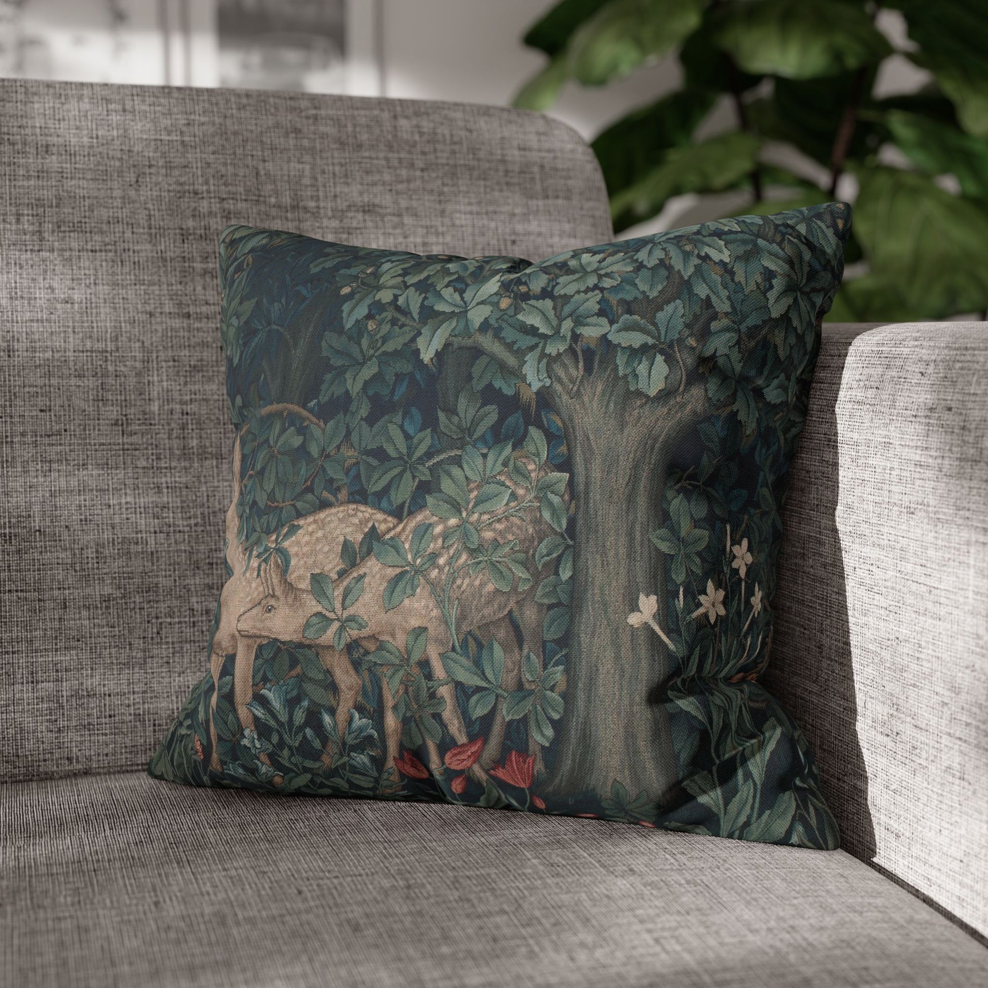 Decorative pillow with a deer and nature design on a gray sofa