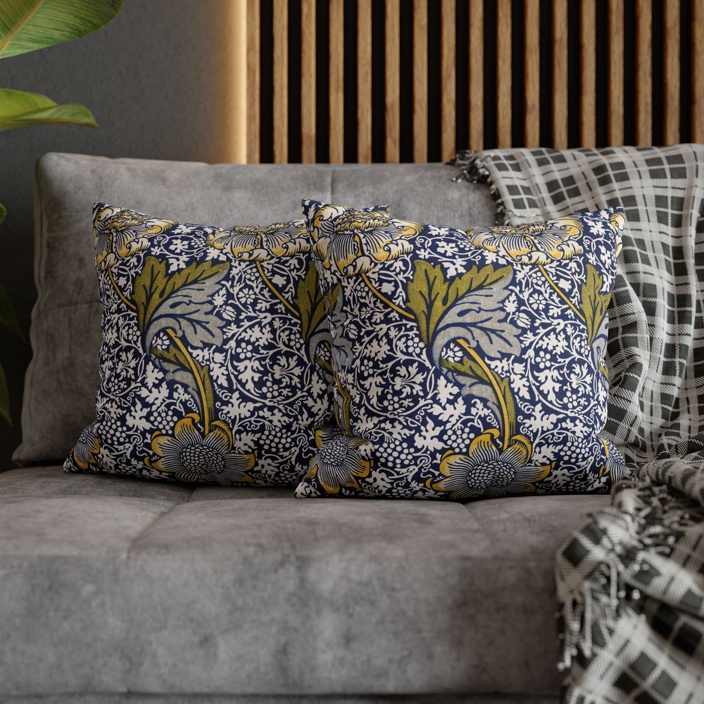 Decorative pillows with floral patterns on a gray sofa.