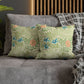 Floral patterned pillows on a gray sofa with a wooden headboard in the background.