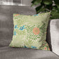 Floral patterned pillow on a gray sofa with a blurred plant in the background