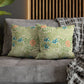 Floral-patterned pillows on a gray sofa with a wooden headboard in the background.