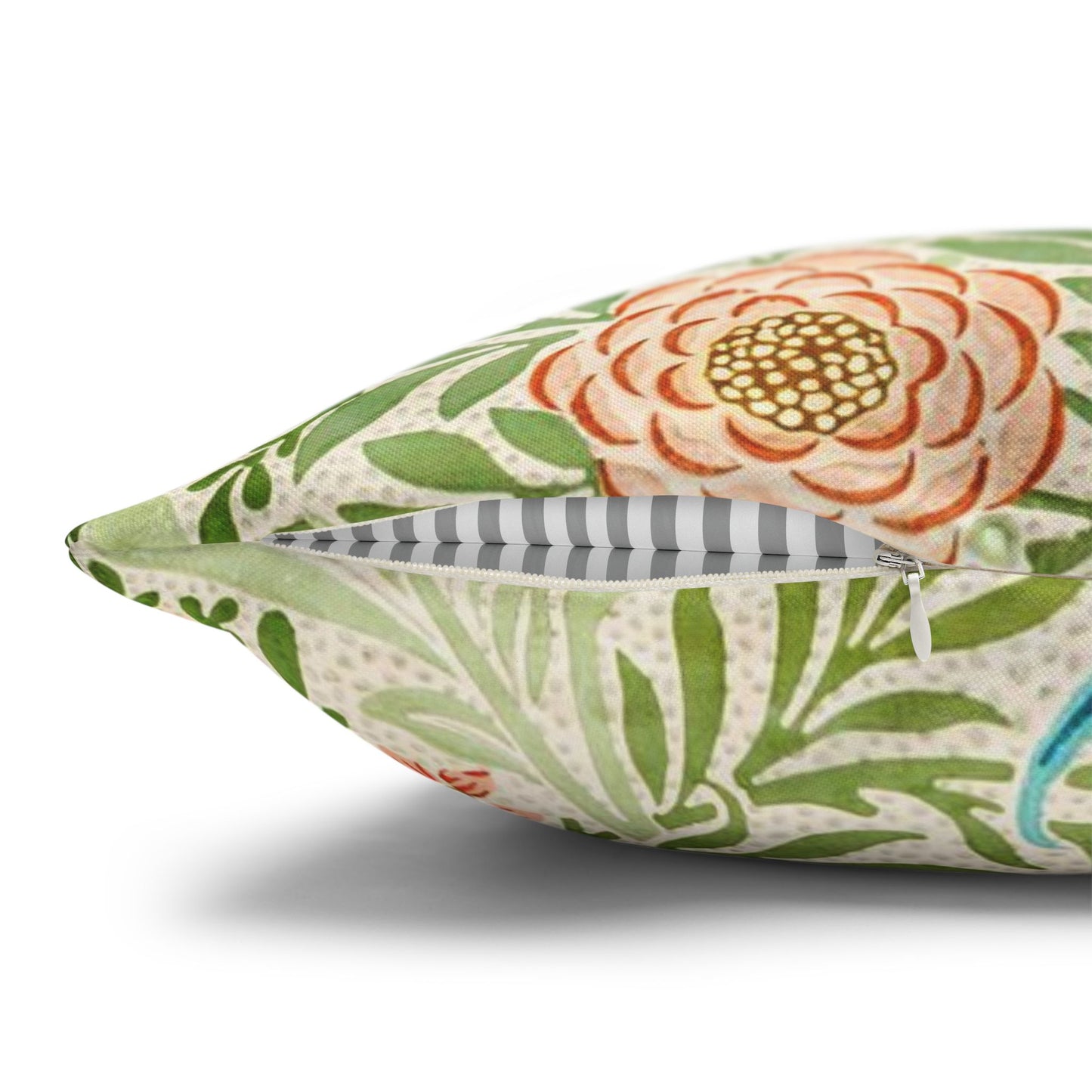 Floral and leaf patterned pillow with a striped interior on a white background