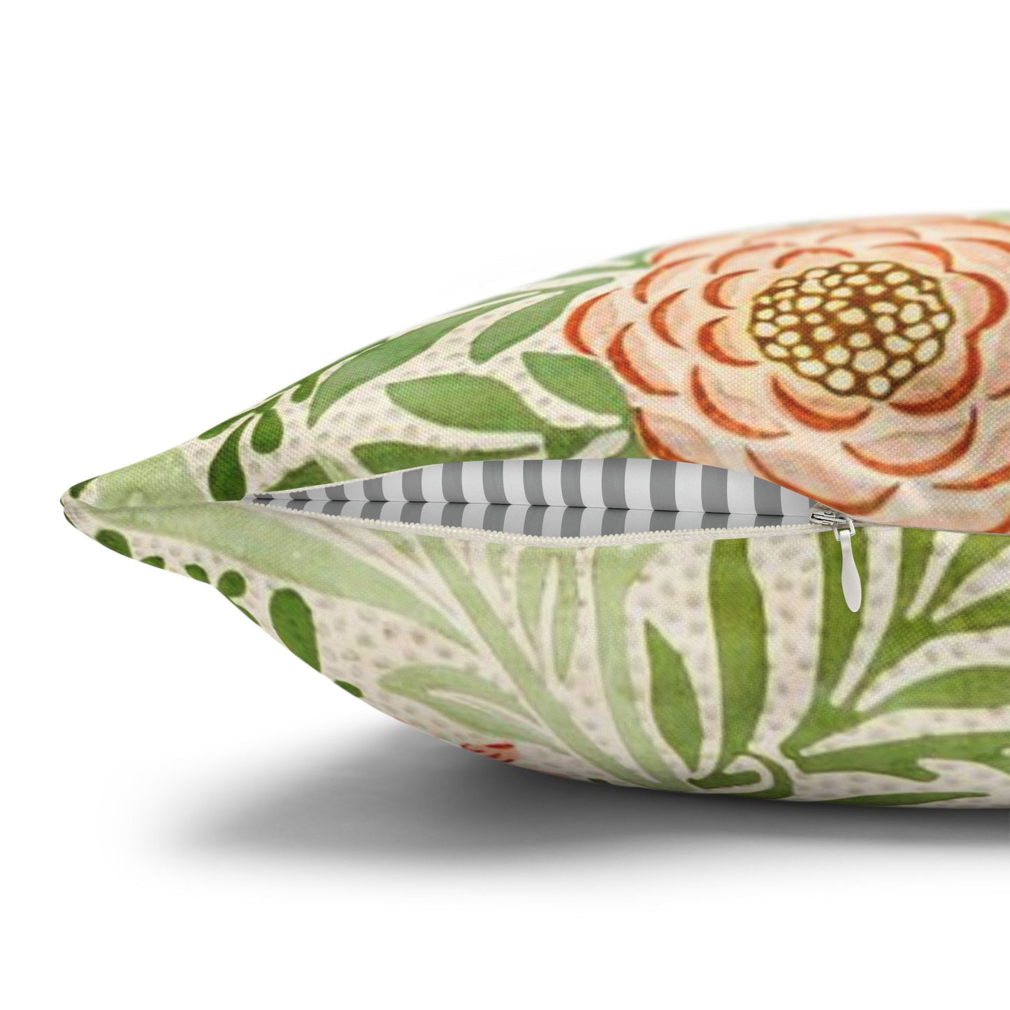 Floral patterned pillow with green leaves and orange flowers on a white background