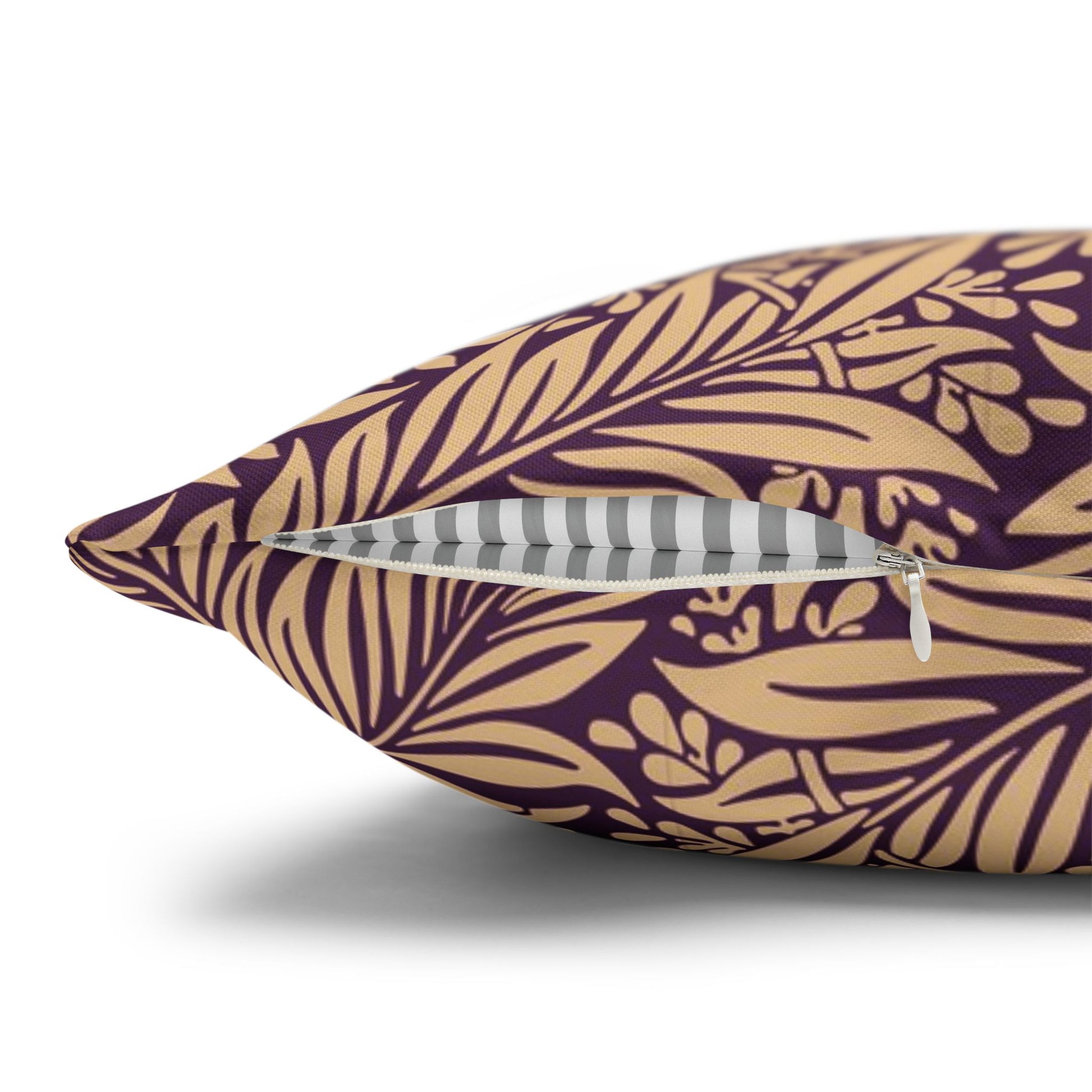 Decorative pillow with purple and gold leaf pattern on a white background