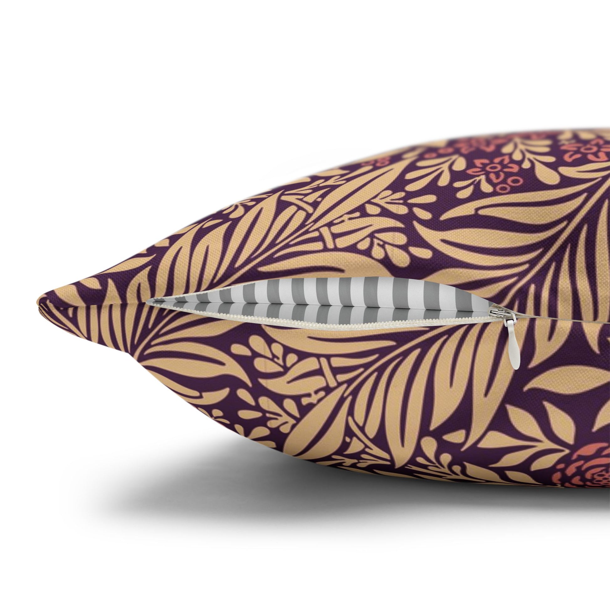 Decorative pillow with purple and gold floral pattern on a white background