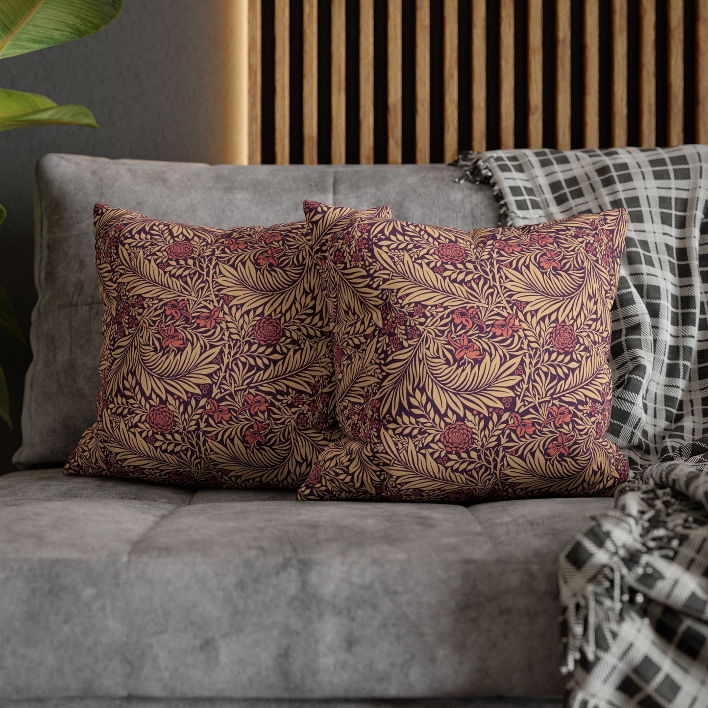 Floral patterned pillows on a gray sofa with a wooden headboard in the background.