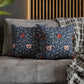 Floral patterned cushions on a gray sofa with a wooden headboard in the background.