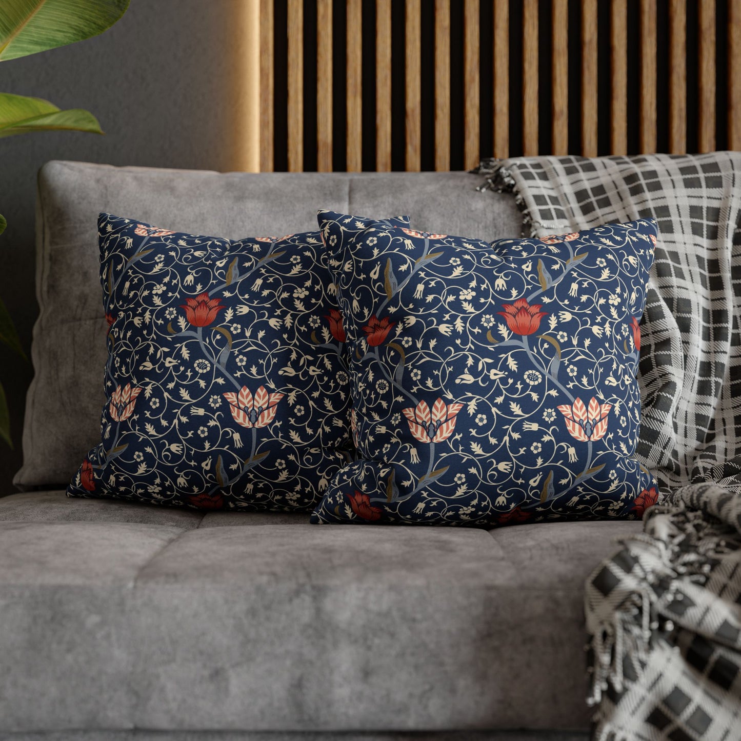 Floral patterned cushions on a gray sofa with a wooden headboard in the background.