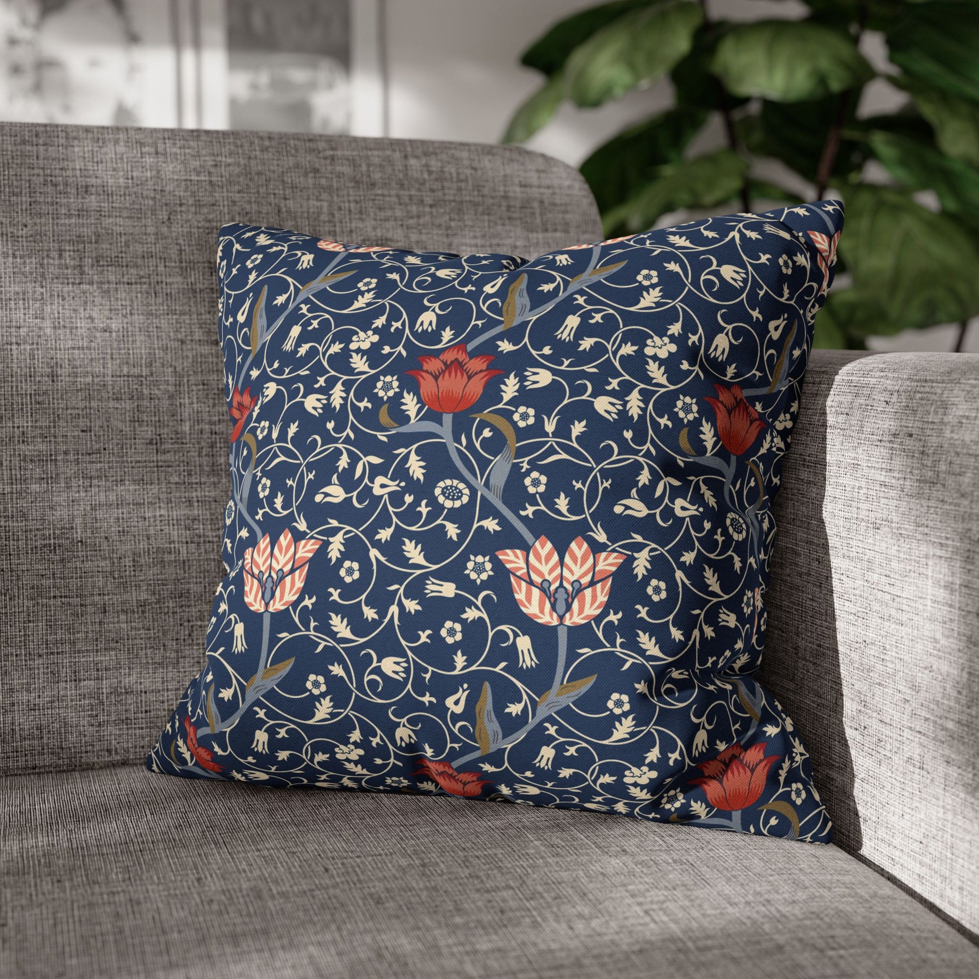 Decorative floral pillow on a gray sofa with a blurred indoor background