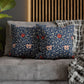 Floral patterned cushions on a gray sofa with a wooden headboard in the background.
