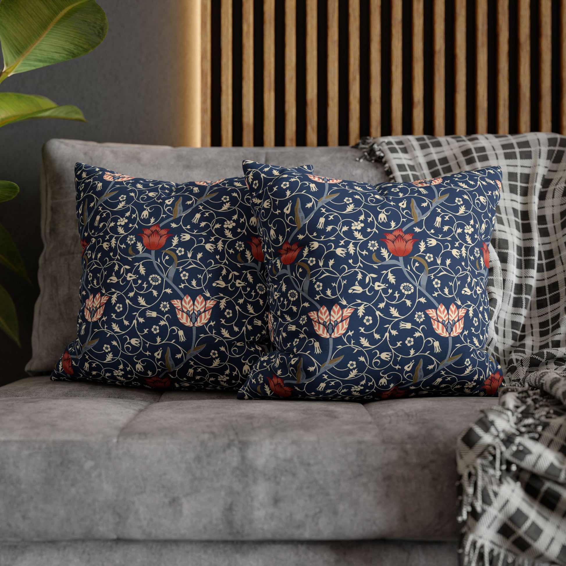 Floral patterned cushions on a gray sofa with a wooden headboard in the background.