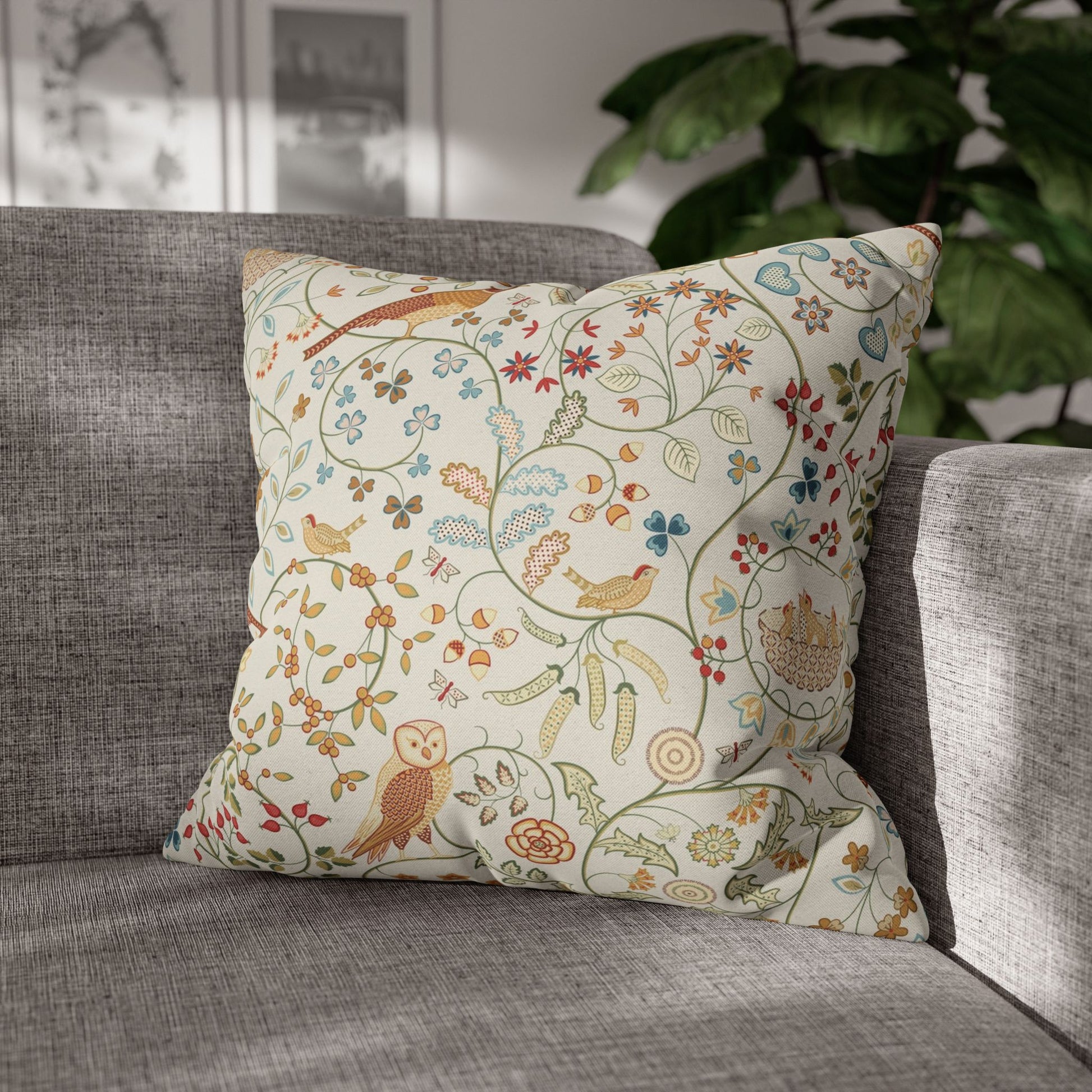 Decorative pillow with floral and bird pattern on a gray sofa