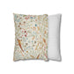 Decorative pillow with floral and bird pattern next to a striped pillow on a white background
