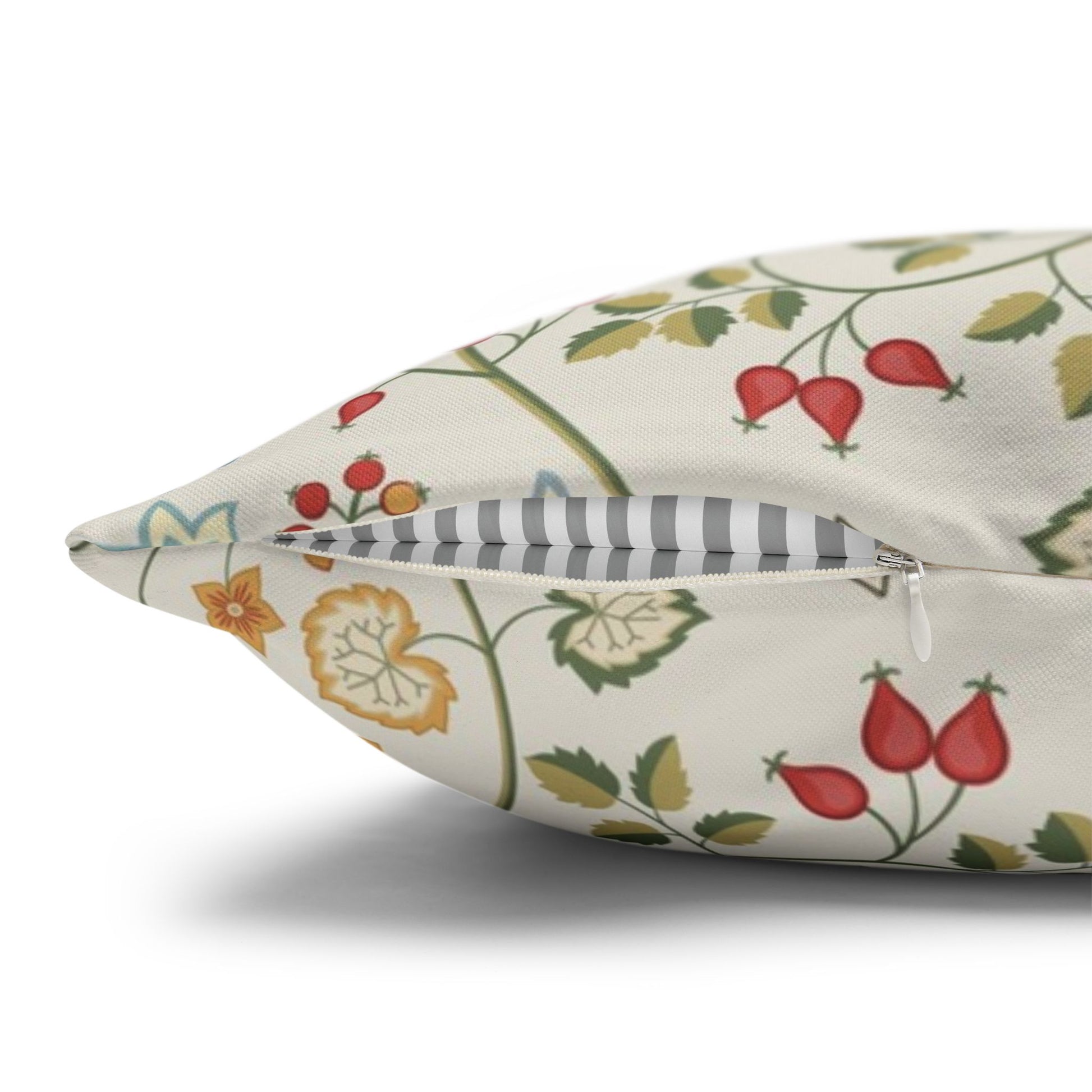 Decorative pillow with floral and berry pattern on a white background