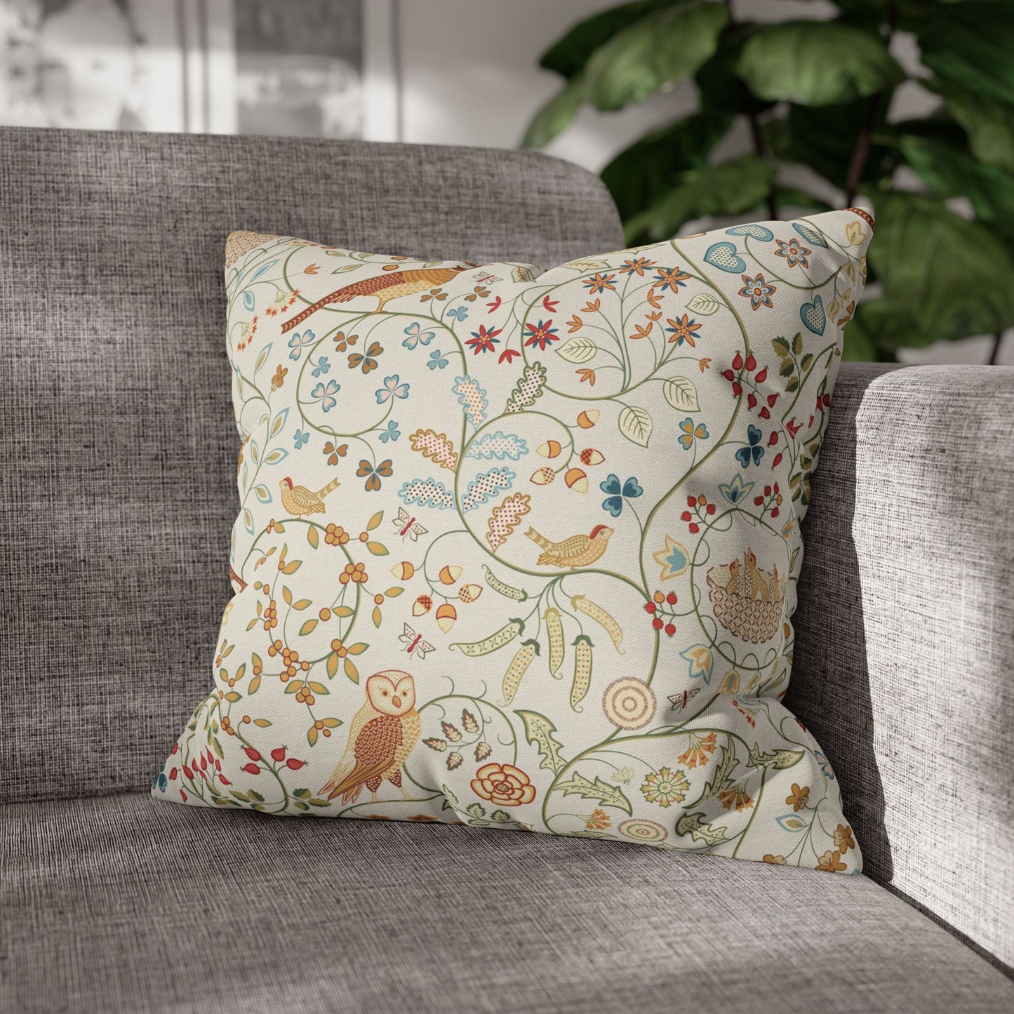 Decorative pillow with floral and bird pattern on a gray sofa