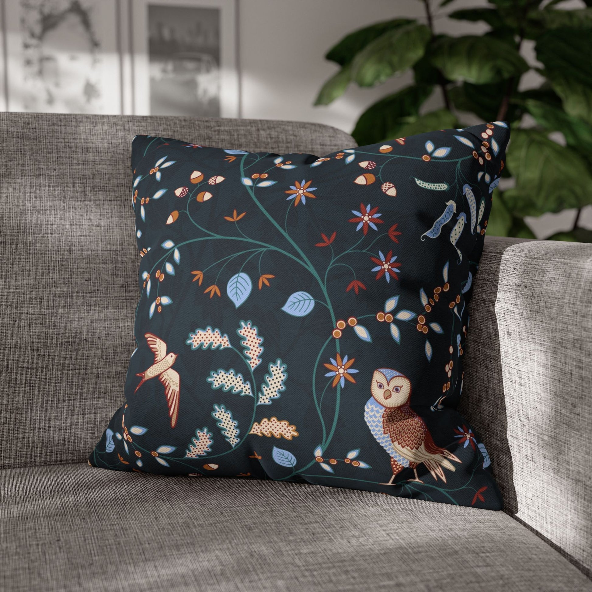 Decorative pillow with owl and floral pattern on a gray sofa