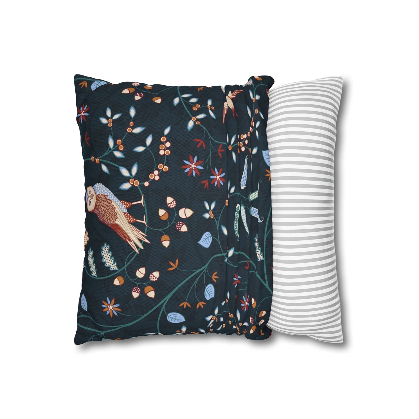 Decorative pillow with nature-themed design next to a plain striped pillow on a white background