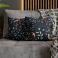 Decorative pillows with floral and bird pattern on a gray sofa.
