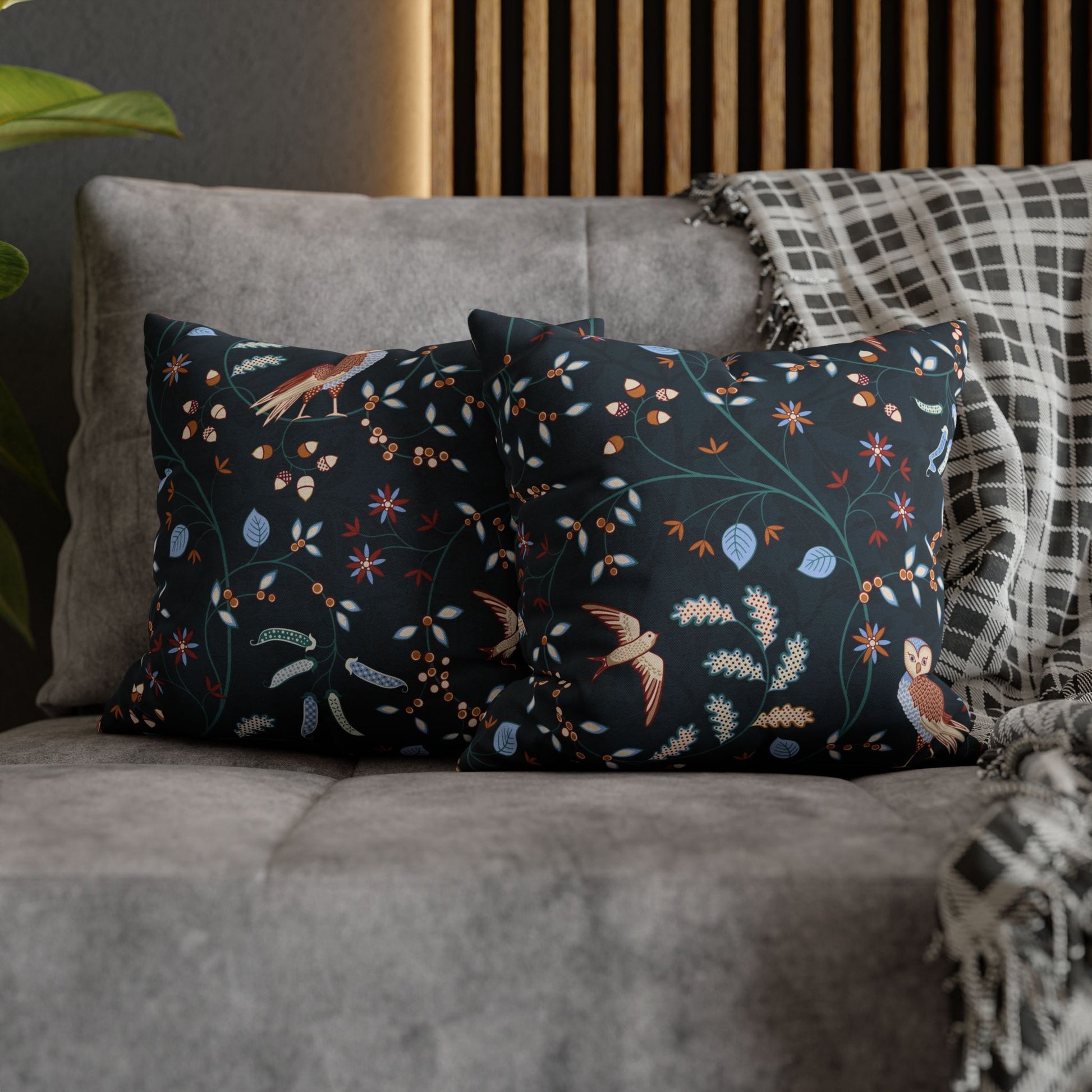 Decorative pillows with floral and bird pattern on a gray sofa.