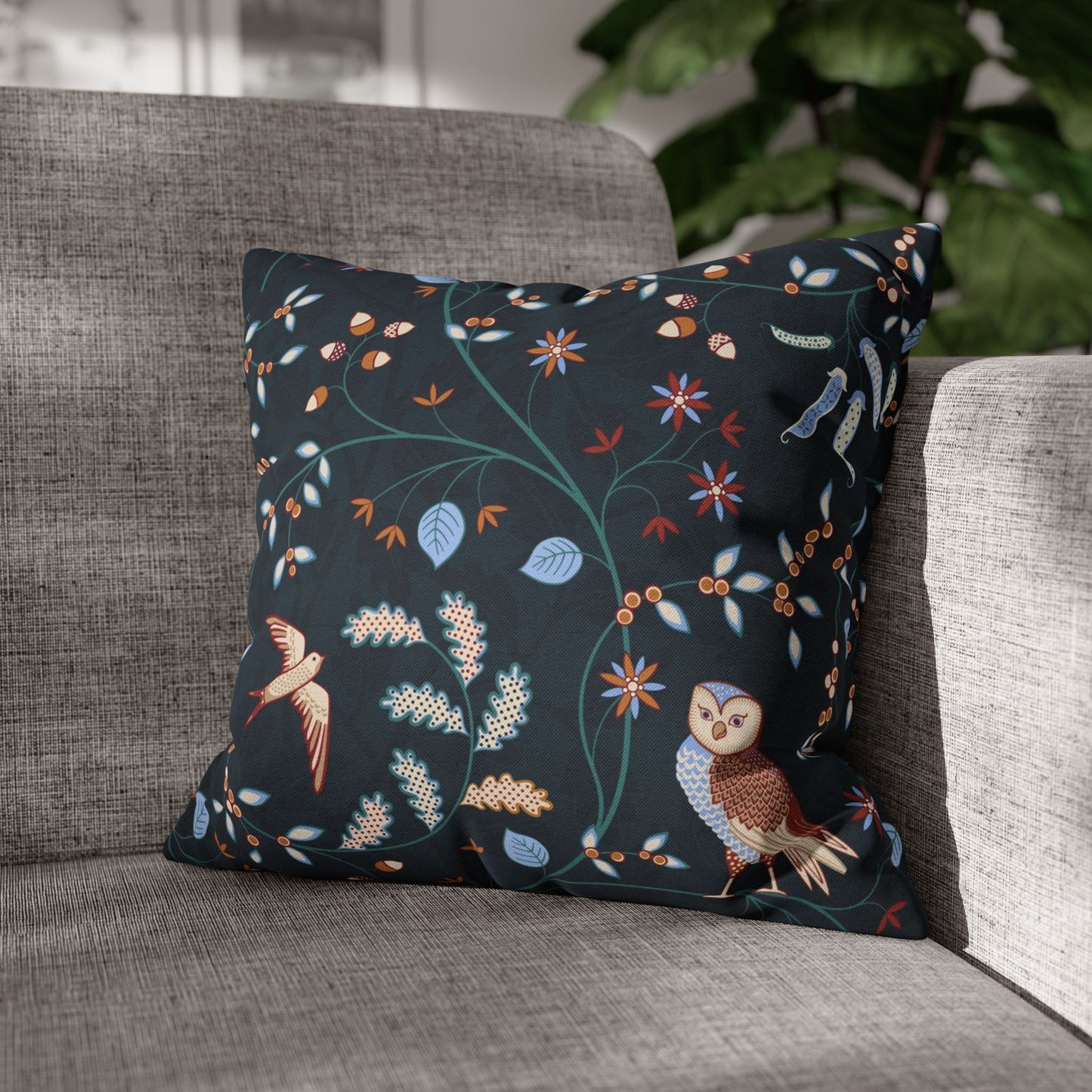 Decorative pillow with floral and bird pattern on a gray sofa