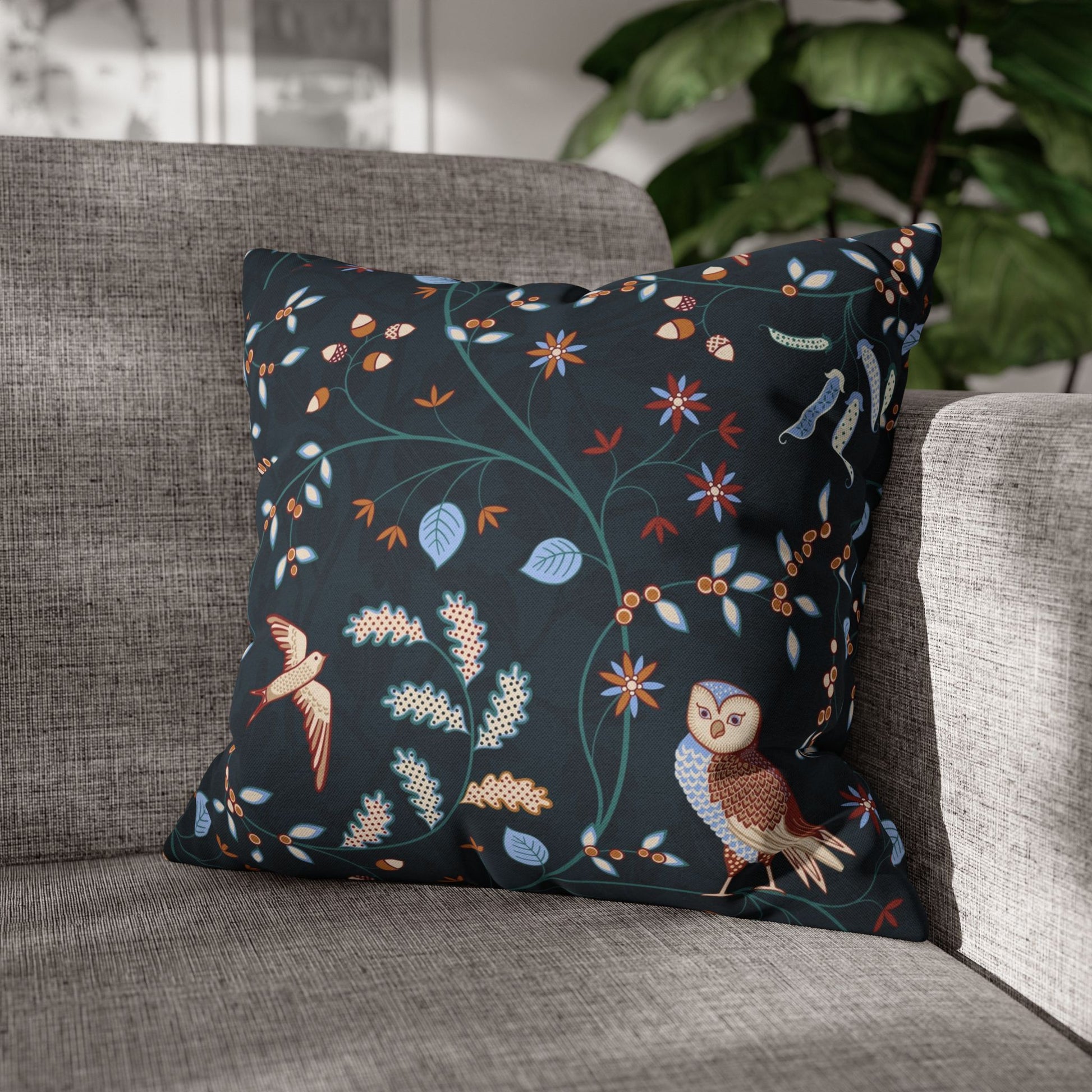 Decorative pillow with floral and bird pattern on a gray sofa