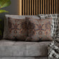 Patterned pillows on a gray sofa with a wooden headboard in the background