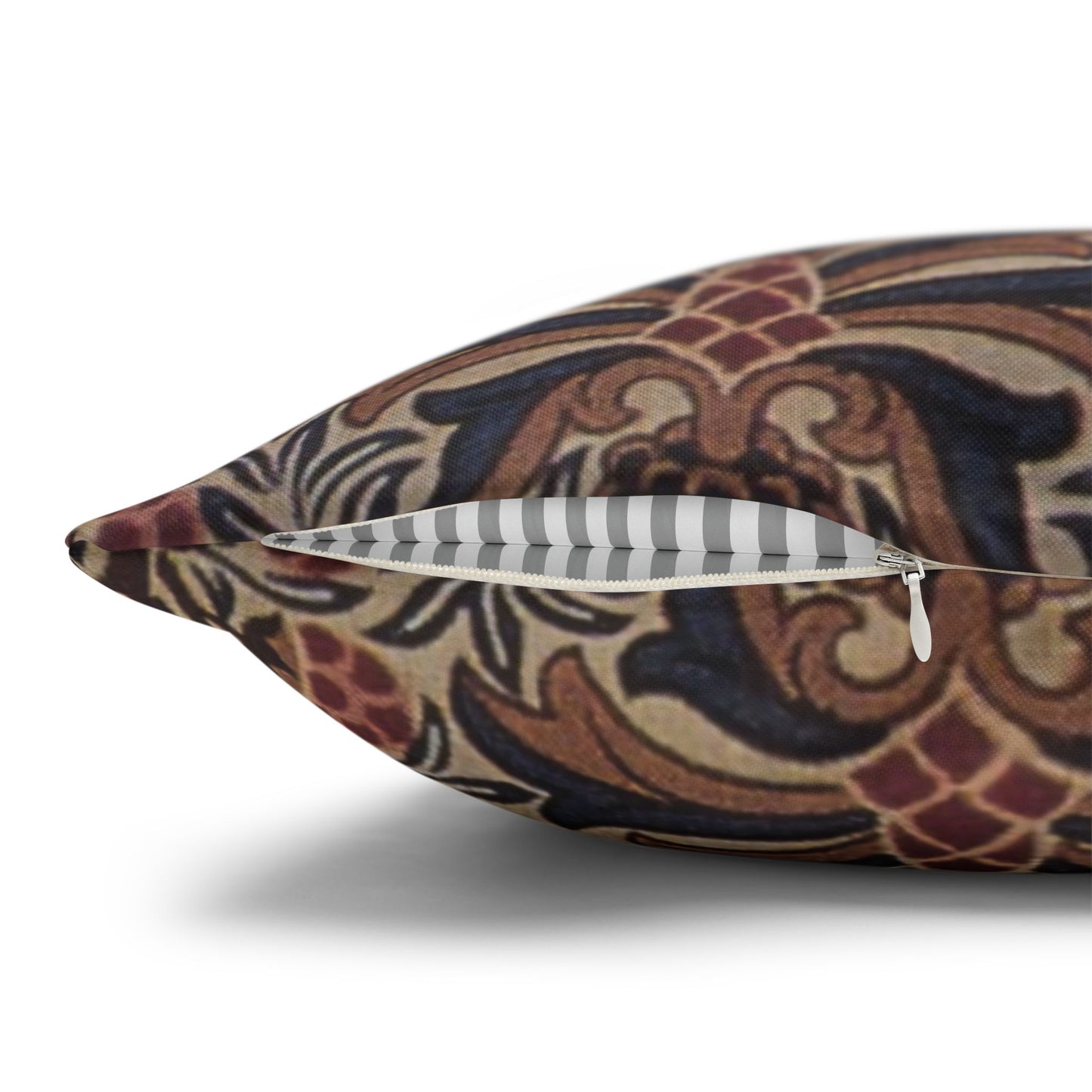 Decorative pillow with intricate patterns and a zipper on a white background
