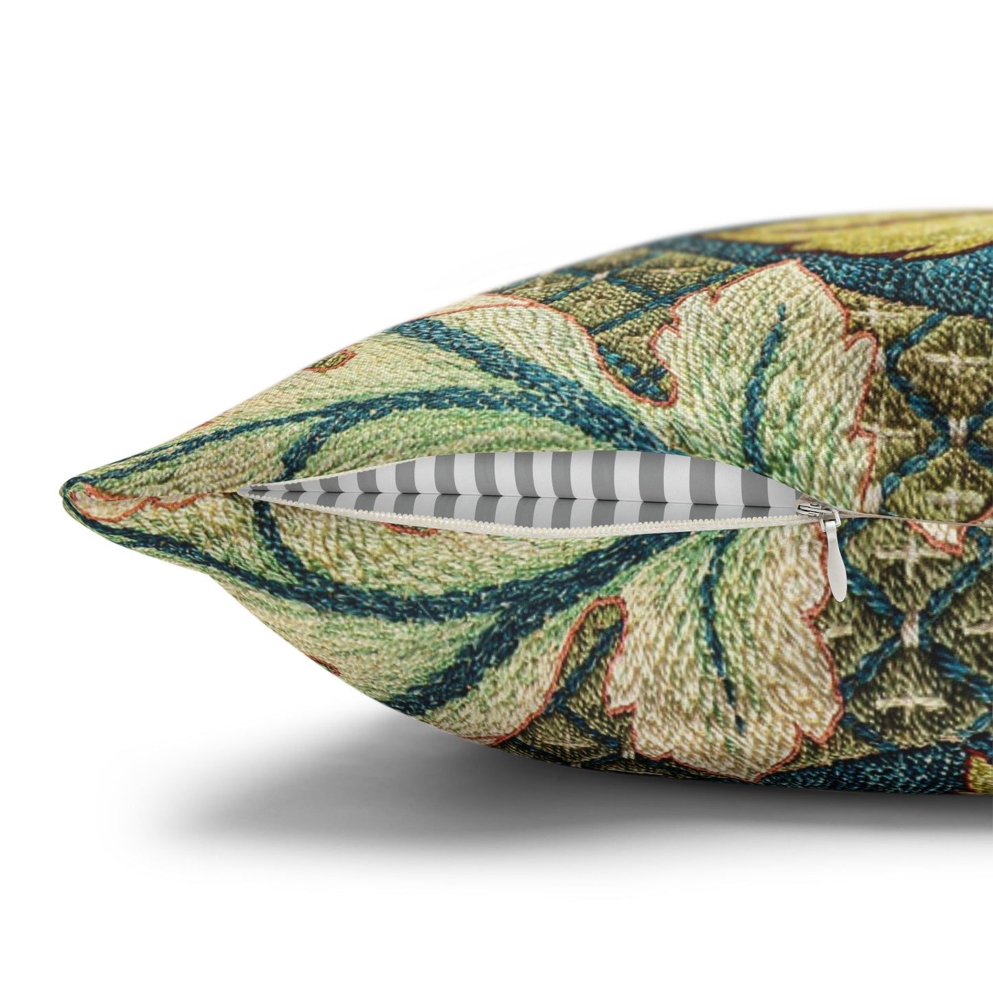 Decorative pillow with intricate leaf pattern and a feather on a white background