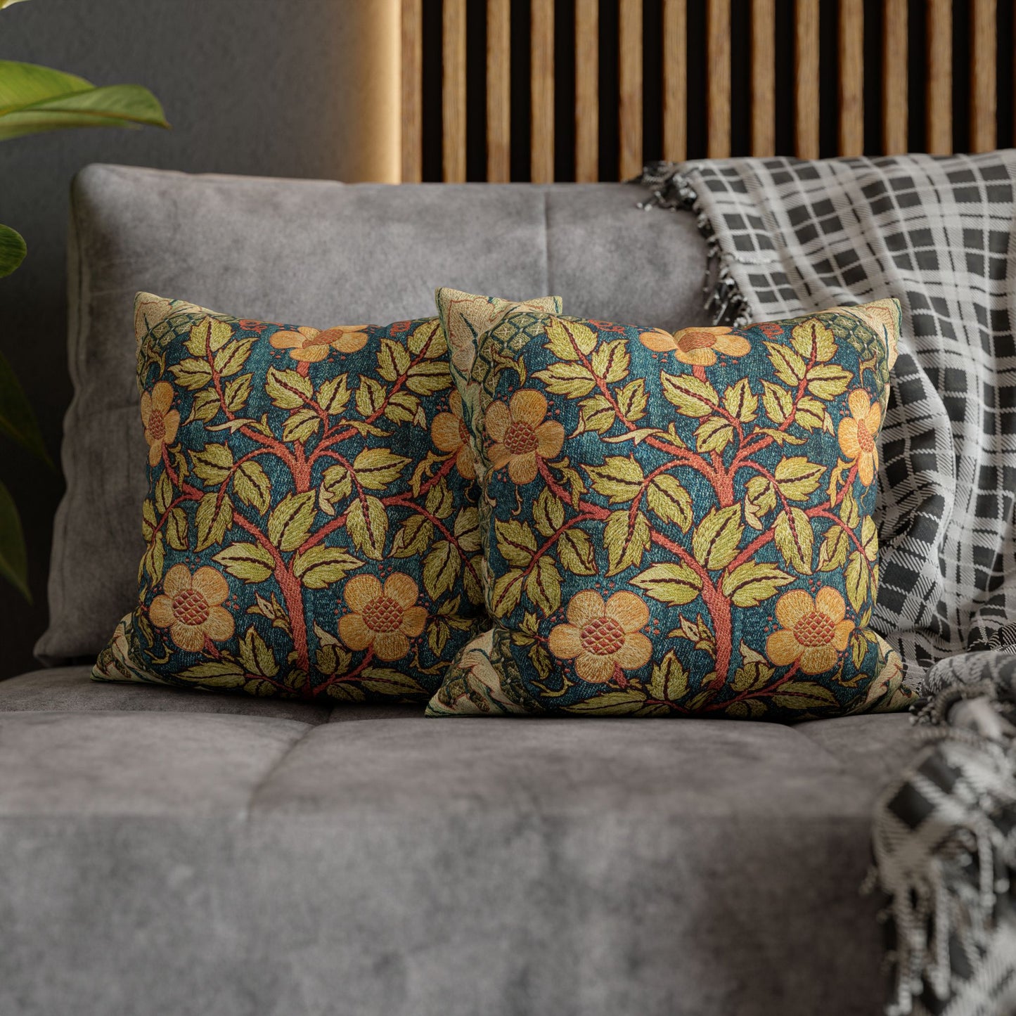 Floral patterned cushions on a gray sofa with a wooden headboard in the background.