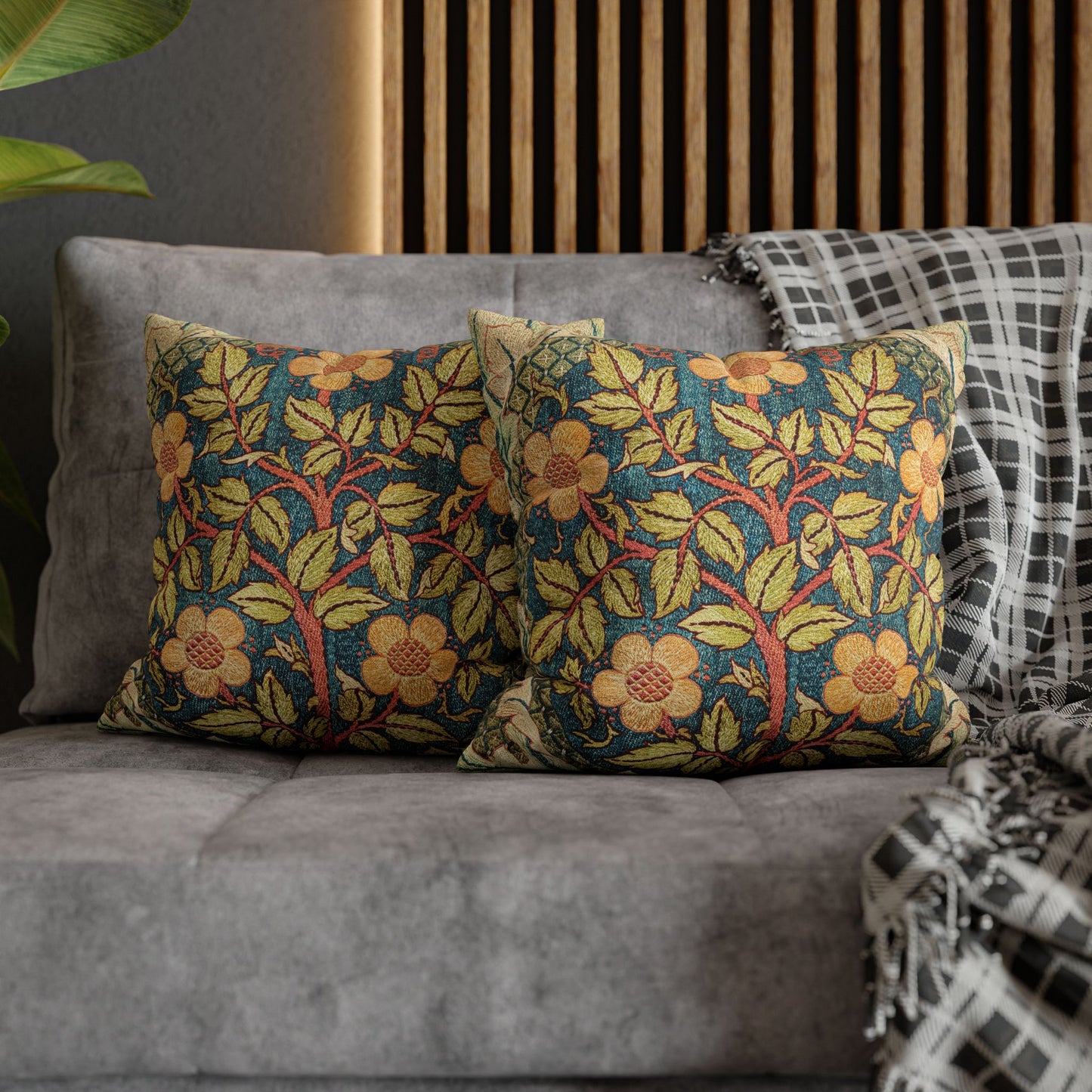 Floral patterned cushions on a gray sofa with a wooden headboard in the background.