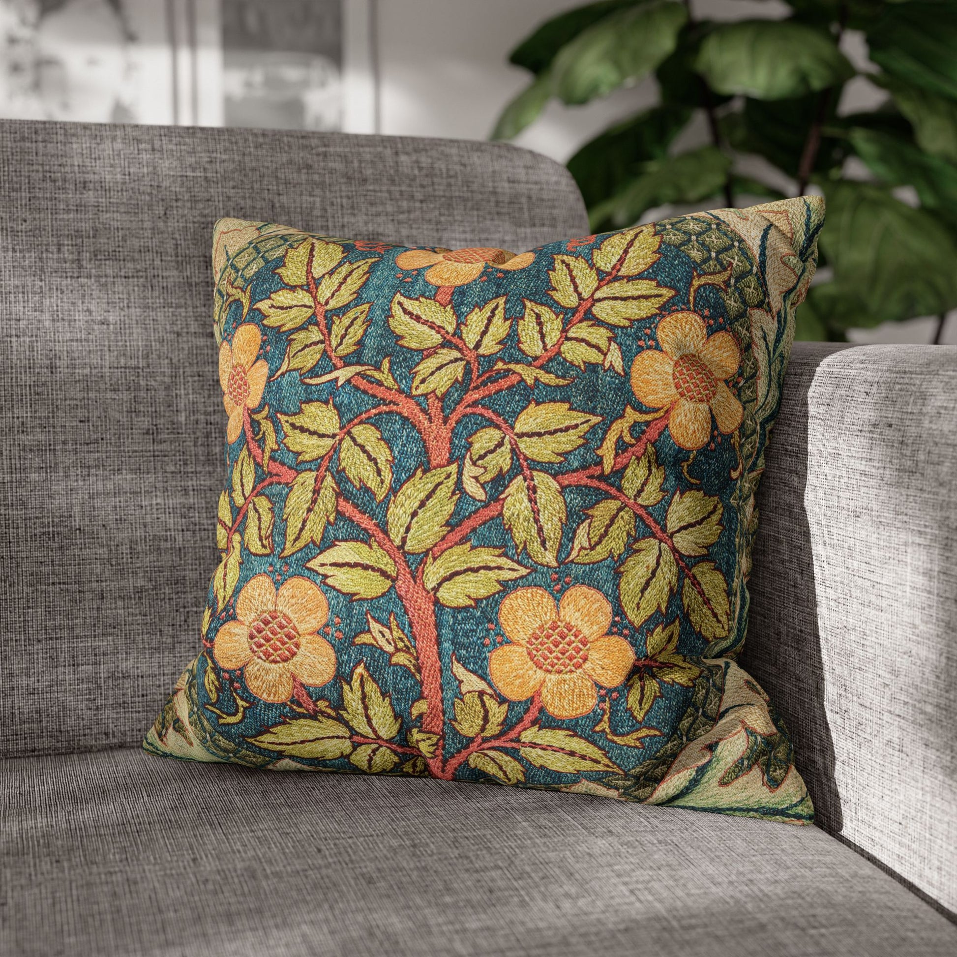 Decorative floral pillow on a gray sofa with a blurred indoor background