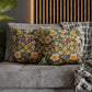 Floral patterned cushions on a gray sofa with a wooden headboard in the background.