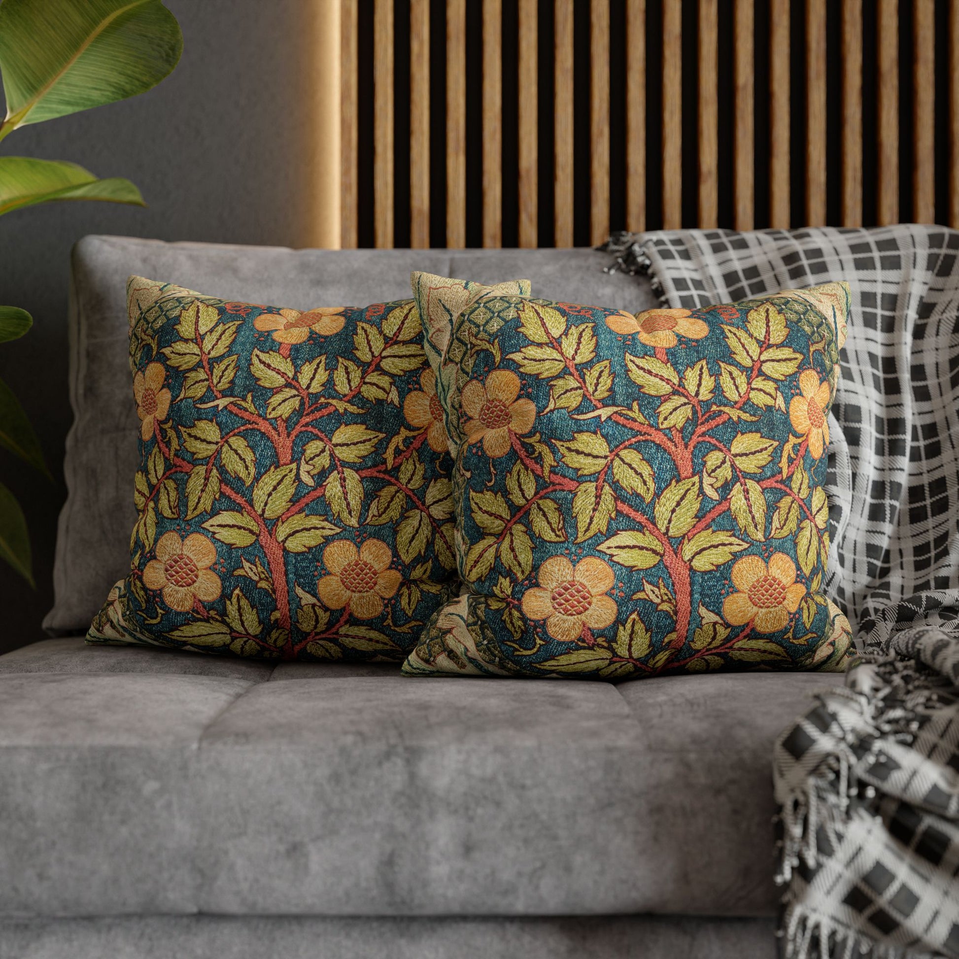 Floral patterned cushions on a gray sofa with a wooden headboard in the background.