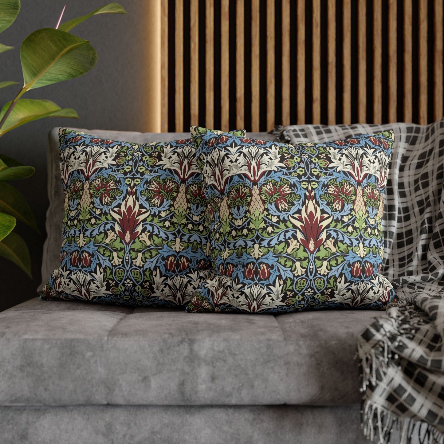 Decorative pillows with a floral pattern on a gray sofa - William Morris Snakeshead