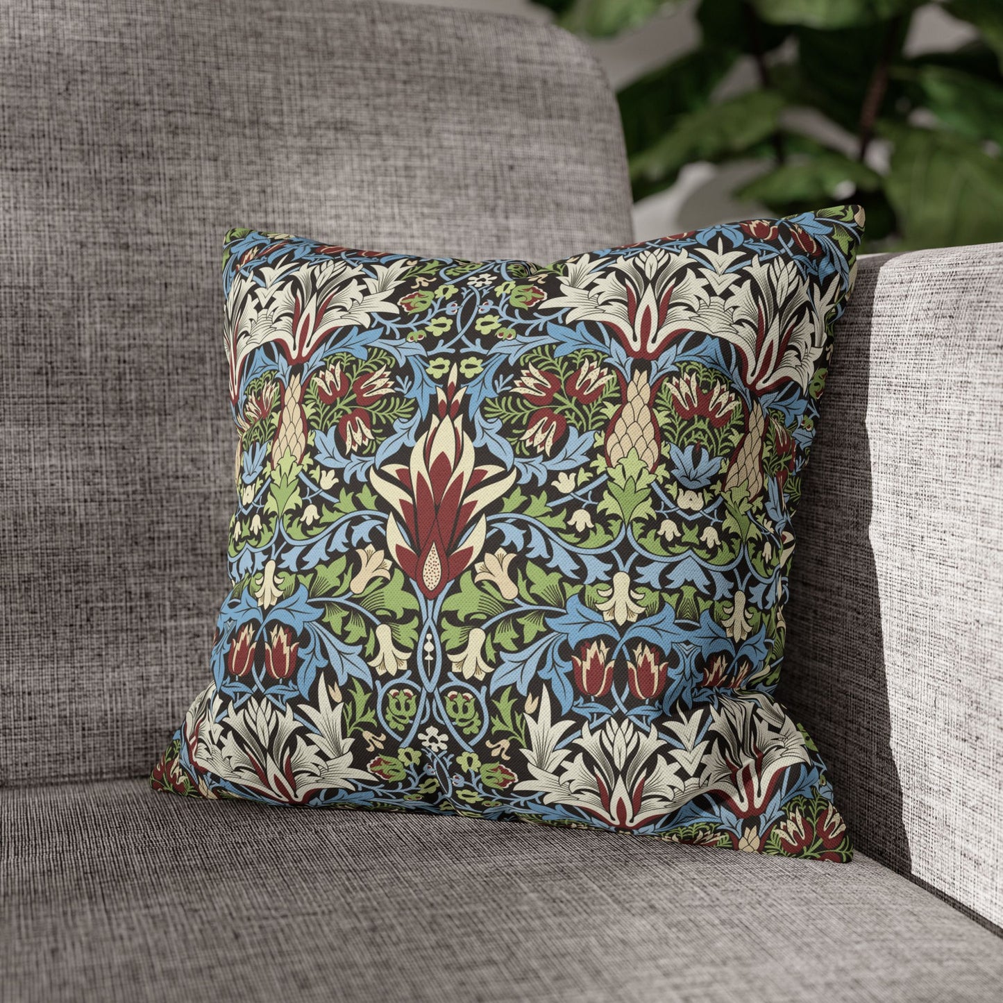 Decorative pillow with floral pattern on a gray sofa - William Morris Snakeshead